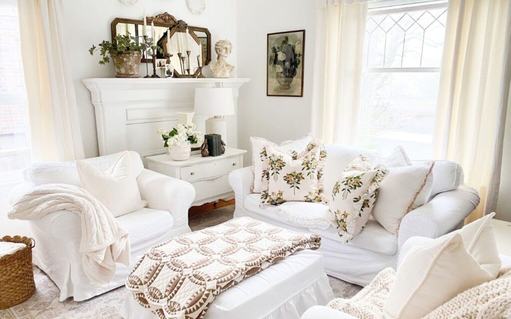 Cozy living room with white slipcovered furniture and antiques layered with cozy throws and pillows