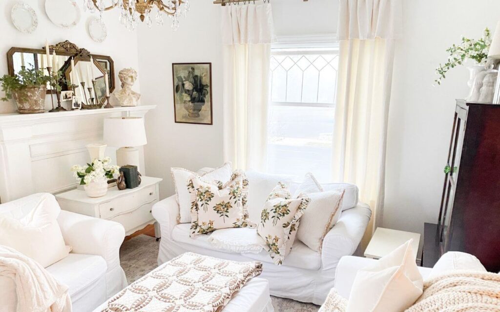Cozy living room with cream floral ruffled pillows and white slipcovered furniture.