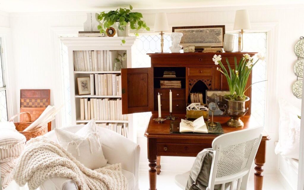 Sunroom home office with antique desk, bookcases, and window film for privacy