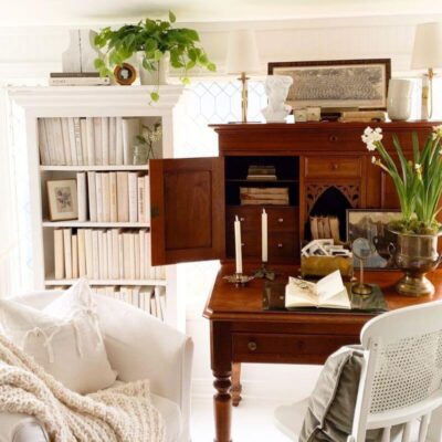 Sunroom home office with antique desk, bookcases, and window film for privacy