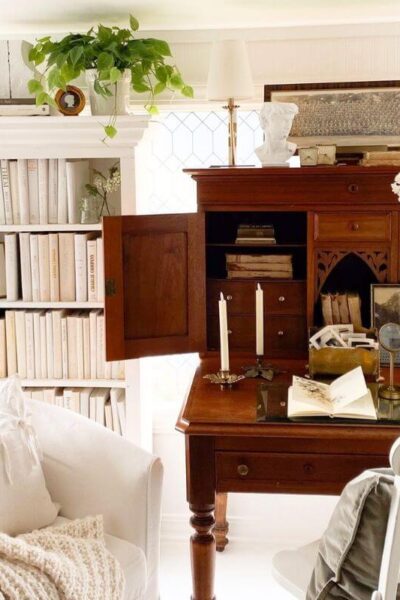 Sunroom home office with antique desk, bookcases, and window film for privacy