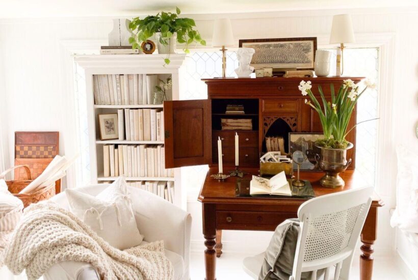 Sunroom home office with antique desk, bookcases, and window film for privacy