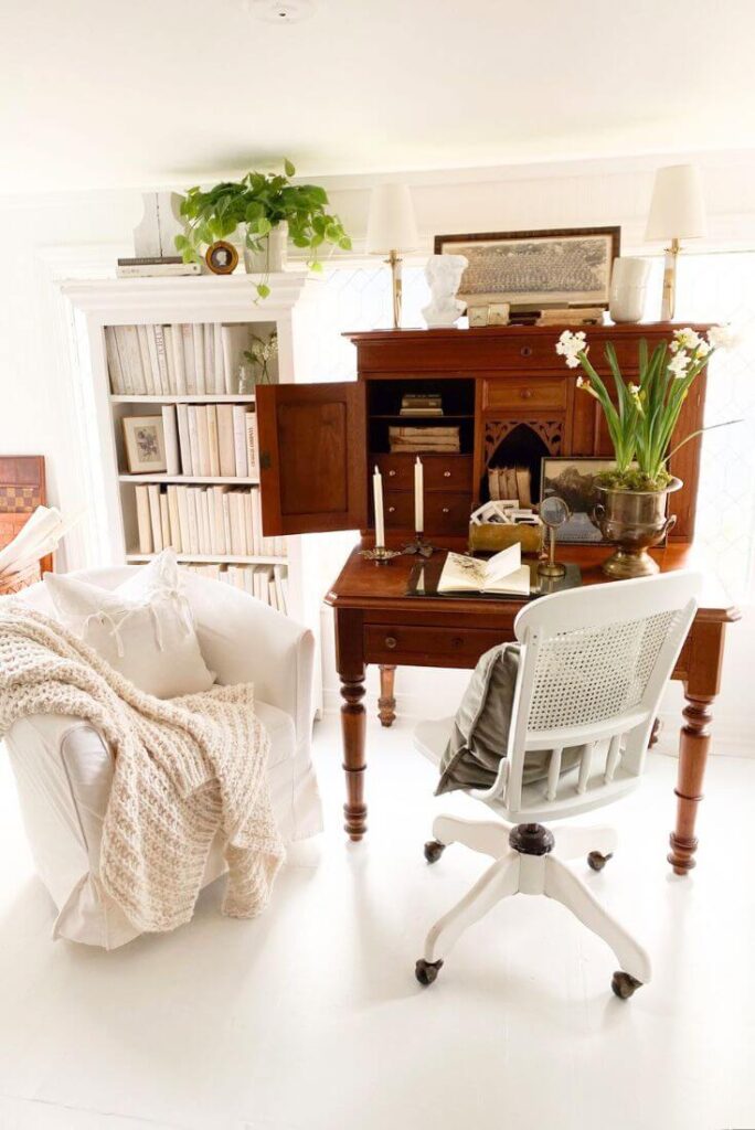 Antique writing desk placed in a light-filled room with surrounding book storage