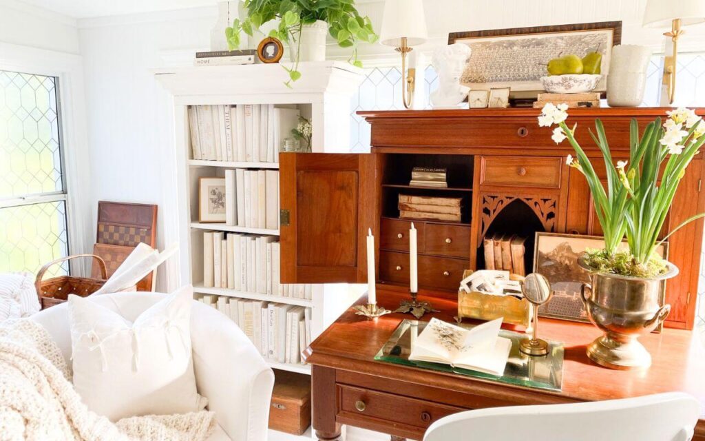 Sunroom office design featuring book storage, collected antiques, and filtered sunlight