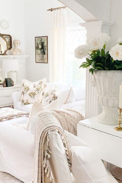 Pre-spring living room decor with layered quilts, floral pillows, and cozy winter textures after Christmas