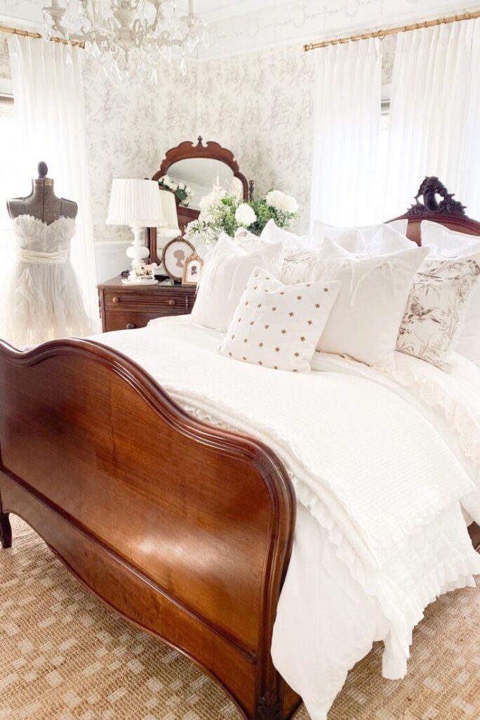 Close-up of ruffled cotton coverlet and eyelet sheets in warm white tones