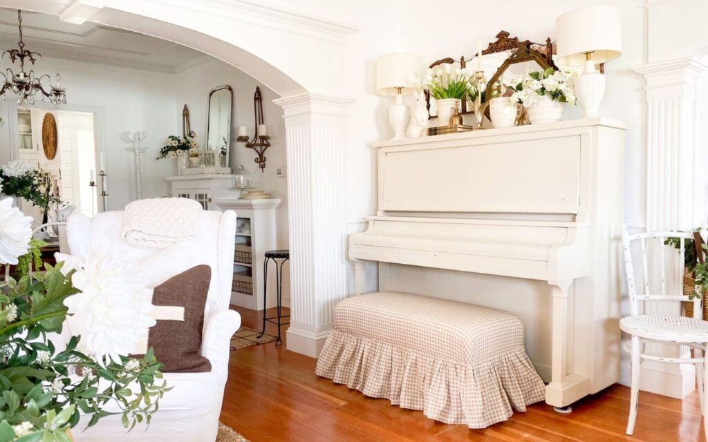Cottage style piano makeover with creamy white painted upright piano and gingham bench