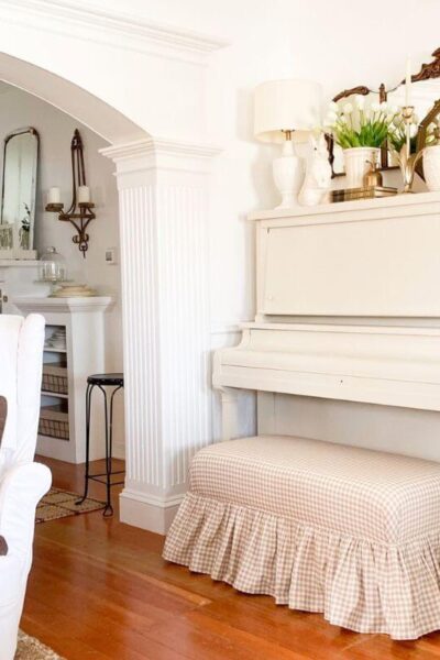 Cottage style piano makeover with creamy white painted upright piano and gingham bench