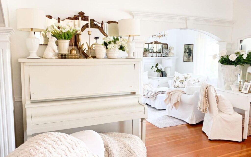 Antique painted piano in a cottage living room styled for spring with with tulips and lilac florals.