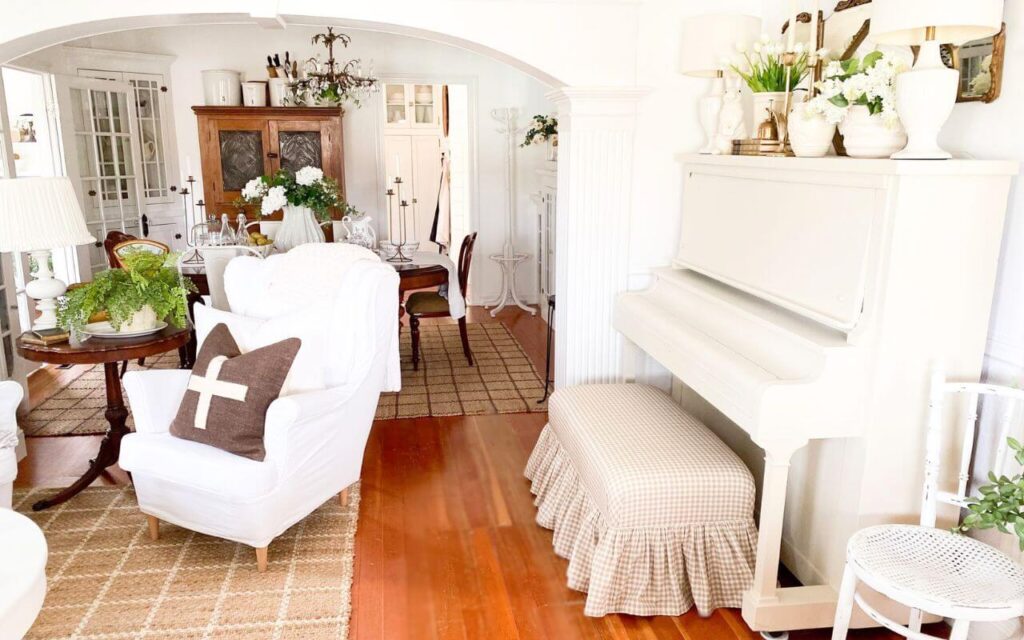 Antique upright piano painted a soft creamy white in a cozy cottage living room