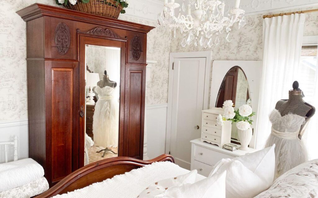 Romantic white bedroom featuring ruffled bedding ideas and antique wood furniture