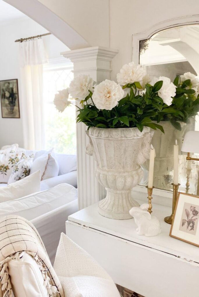 White flowers in a large urn for a cottage entrance.