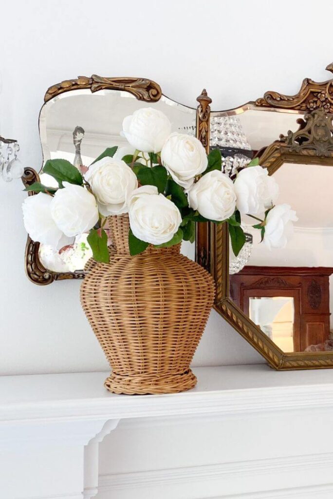 AFloral realistic white roses on the mantle.