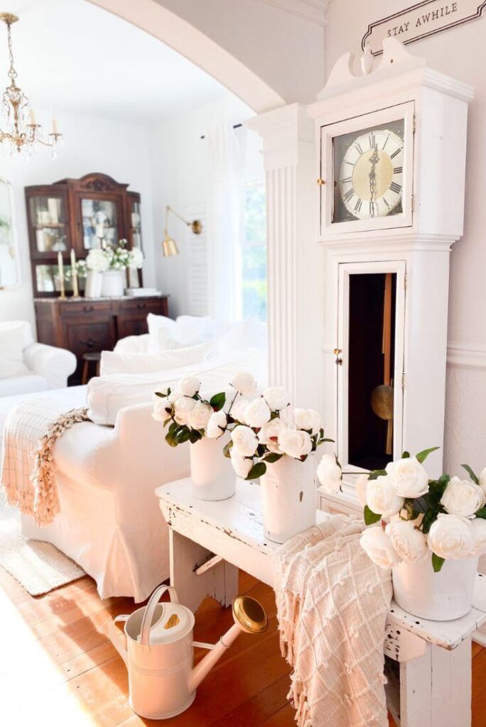 Antique sap buckets and faux white roses for a cottage entryway.