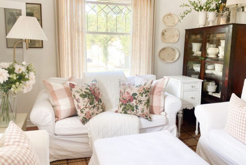Pink cottage decor with floral pillows and gingham accents on white slipcovered furnitures