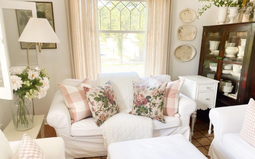 Cabbage rose pillows, pink buffalo check pillows and a ruffled quilt for a quick cottage living room refresh